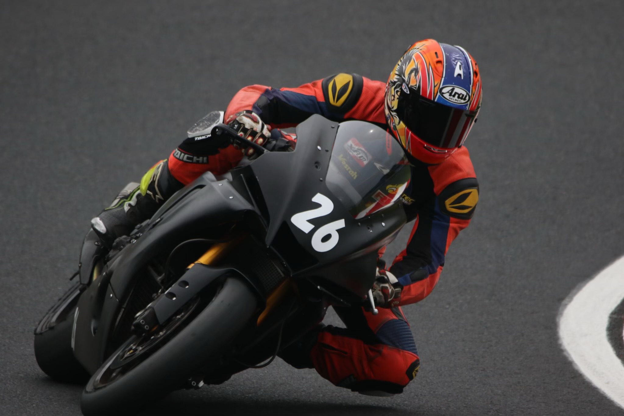 鈴鹿8耐で黒いゼッケン26を深く傾けて走るライダー