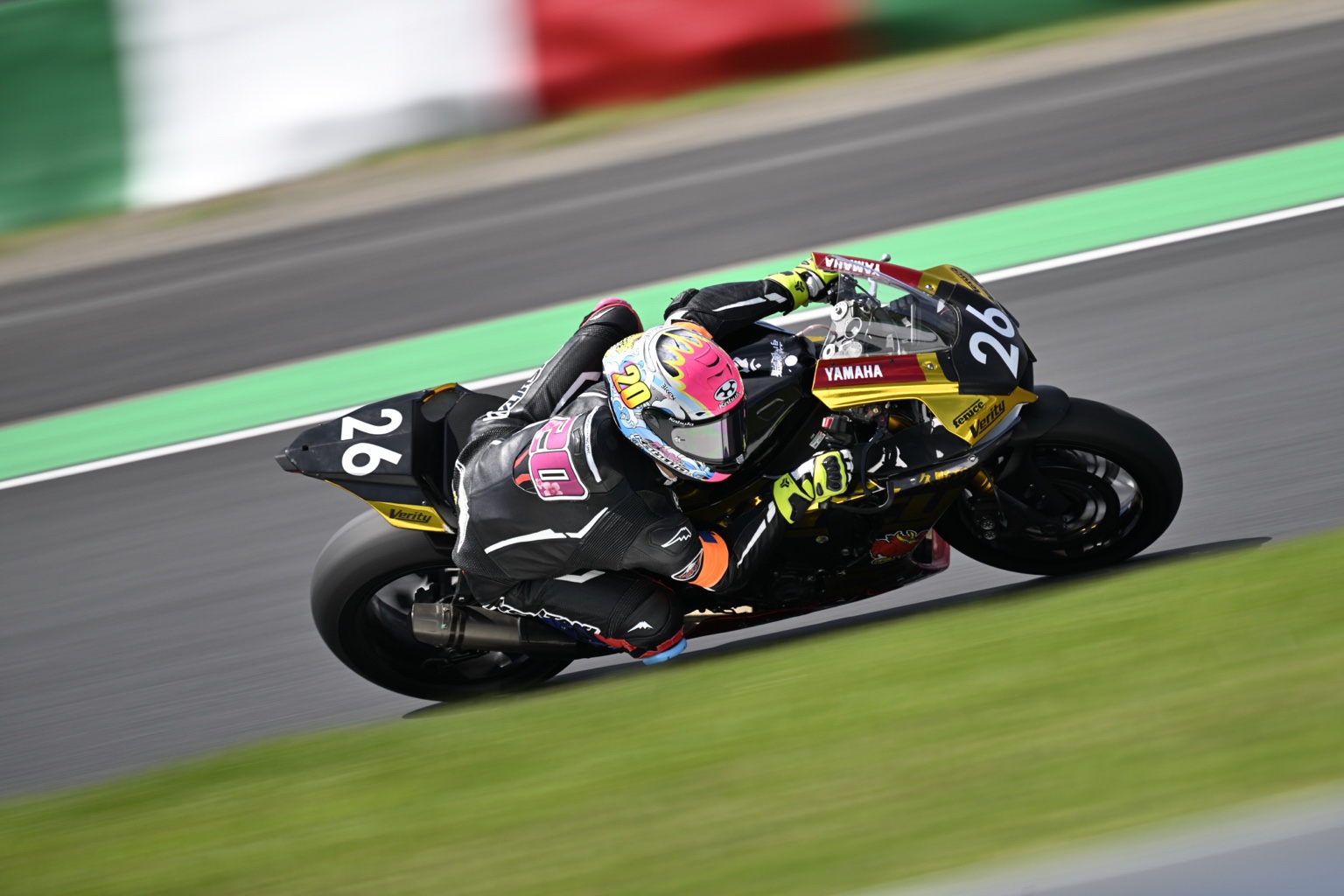 黒と金のゼッケン26を走らせるライダー