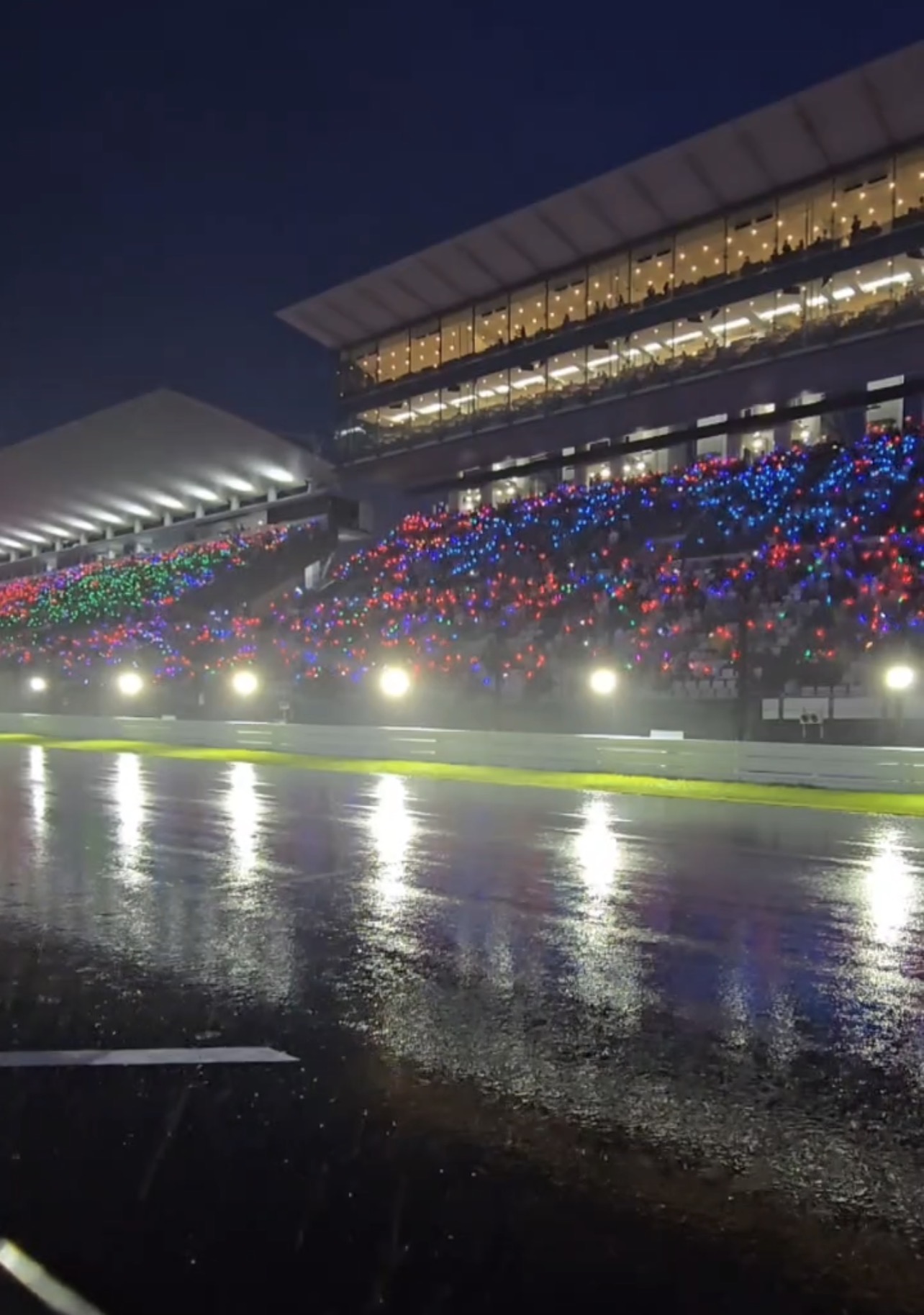雨の夜に応援の光が輝く鈴鹿8耐のグランドスタンド